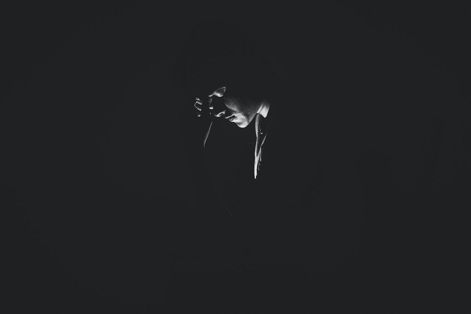 monochrome photography of person on dark room